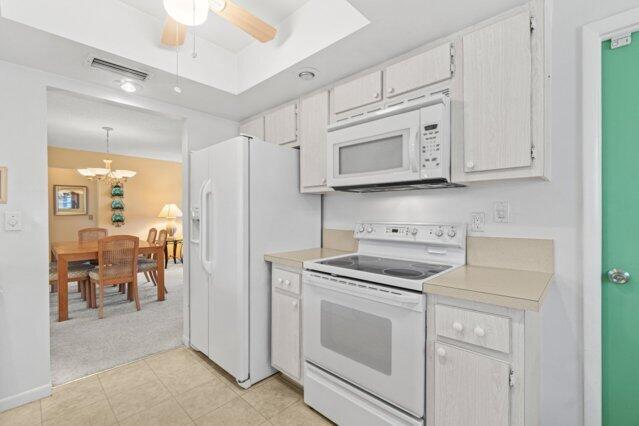 kitchen with white appliances, light countertops, a chandelier, and a ceiling fan