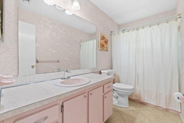 bathroom featuring toilet, tile patterned floors, and vanity