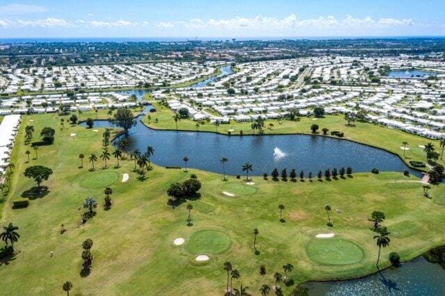 drone / aerial view of a large body of water and a golf club