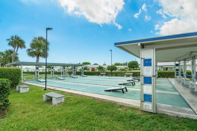 surrounding community featuring shuffleboard and a yard