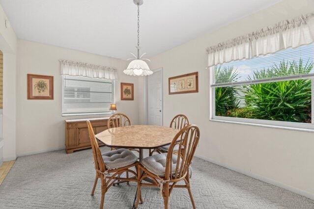 dining space featuring light carpet
