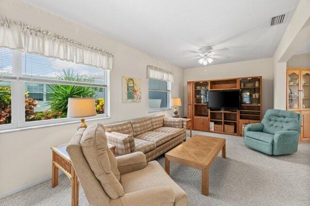 living room featuring carpet flooring, a ceiling fan, and baseboards