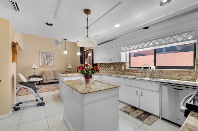 kitchen with tasteful backsplash, a sink, a kitchen island, dishwasher, and white cabinets