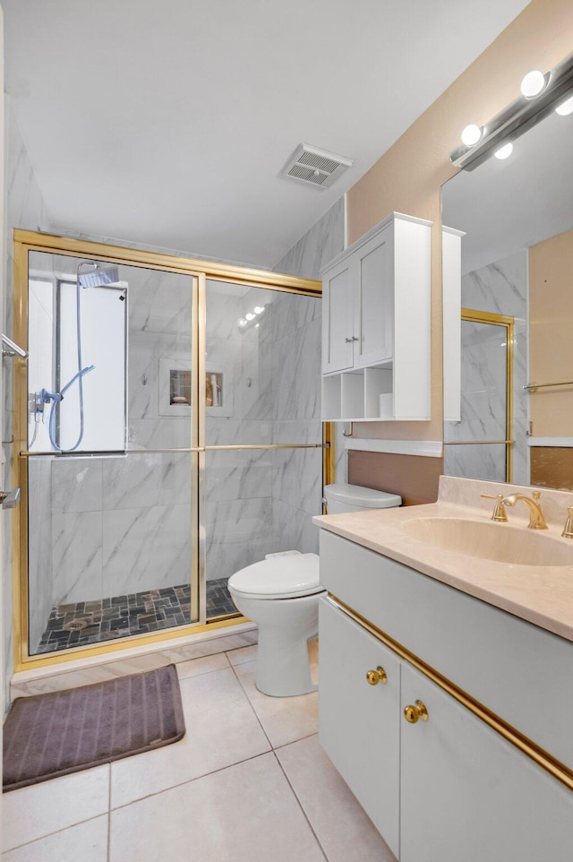 full bath featuring toilet, a marble finish shower, vanity, and tile patterned floors
