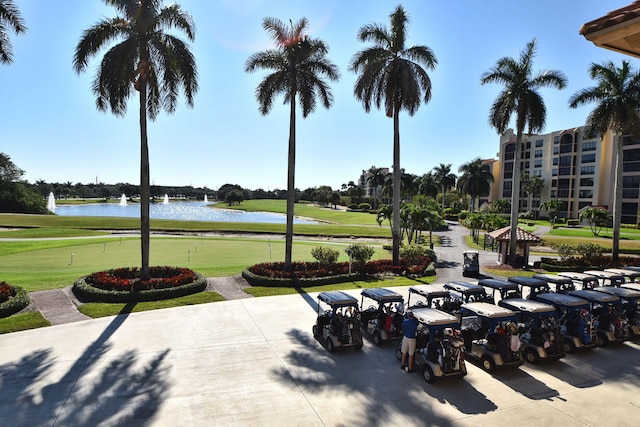 view of community featuring a water view, golf course view, an area to practice putting, and a lawn