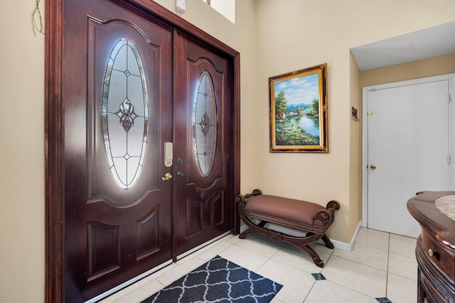 entryway with baseboards and light tile patterned floors