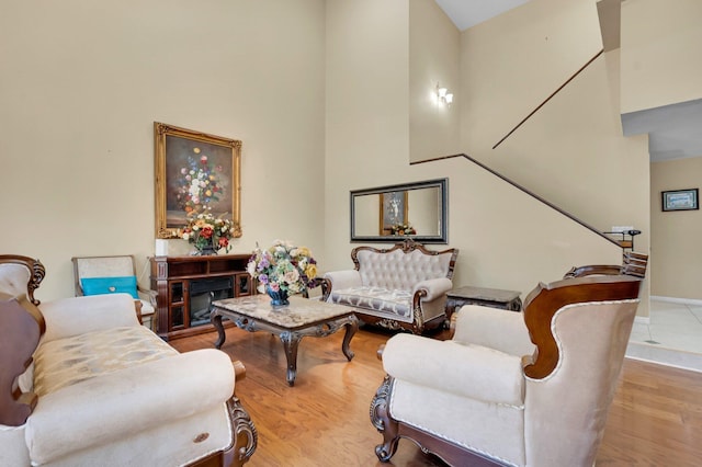 living area featuring a high ceiling, wood finished floors, and baseboards