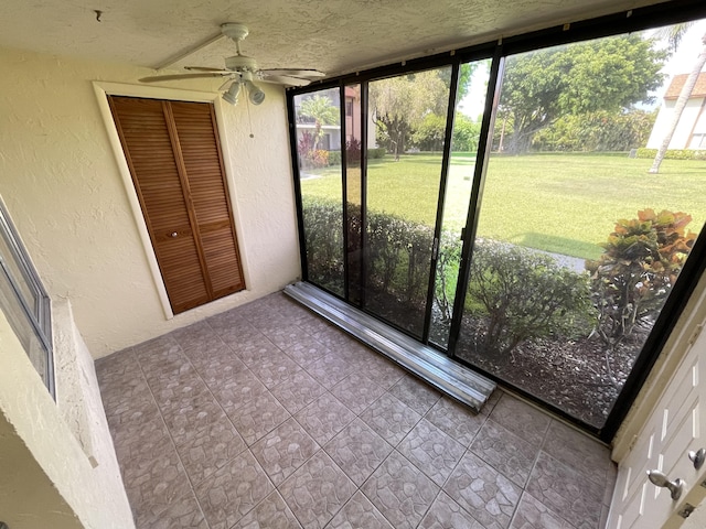 unfurnished sunroom featuring a ceiling fan