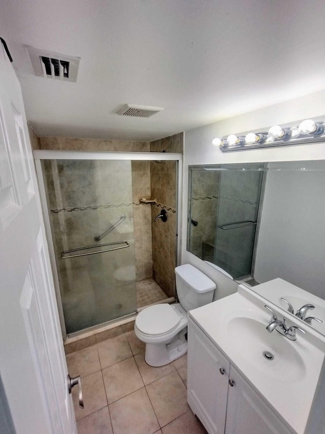 bathroom featuring a stall shower, toilet, tile patterned flooring, and vanity