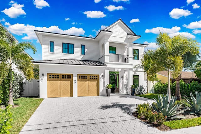 1105 NE 2nd Ave, Delray Beach, FL 33444 - view of front facade with a standing seam roof, decorative driveway, a balcony, an attached garage, and metal roof