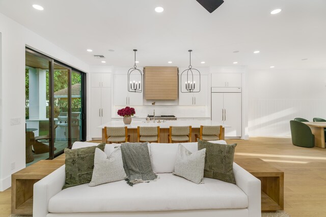 1105 NE 2nd Ave, Delray Beach, FL 33444 - living area with light wood-style flooring, a chandelier, recessed lighting, and a wainscoted wall