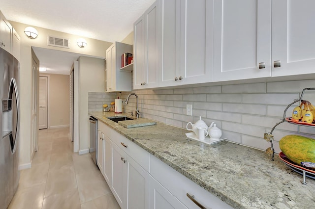 6328 Longboat Ln Unit 302, Boca Raton, FL 33433 - kitchen with appliances with stainless steel finishes, a sink, decorative backsplash, light tile patterned floors, and a textured ceiling