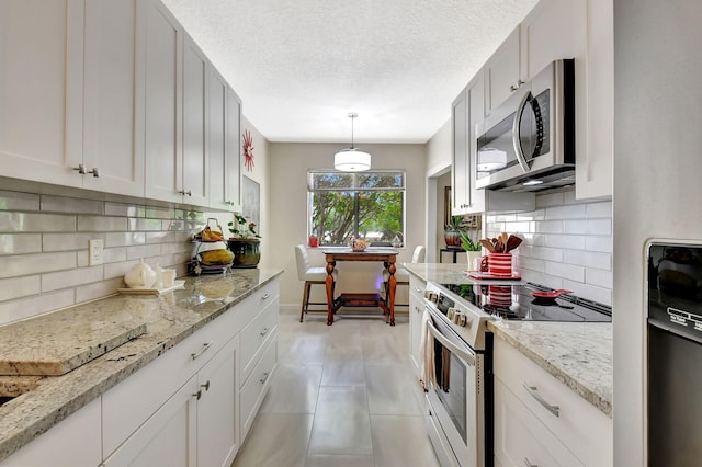 6328 Longboat Ln Unit 302, Boca Raton, FL 33433 - kitchen featuring appliances with stainless steel finishes, decorative backsplash, light stone counters, and a textured ceiling