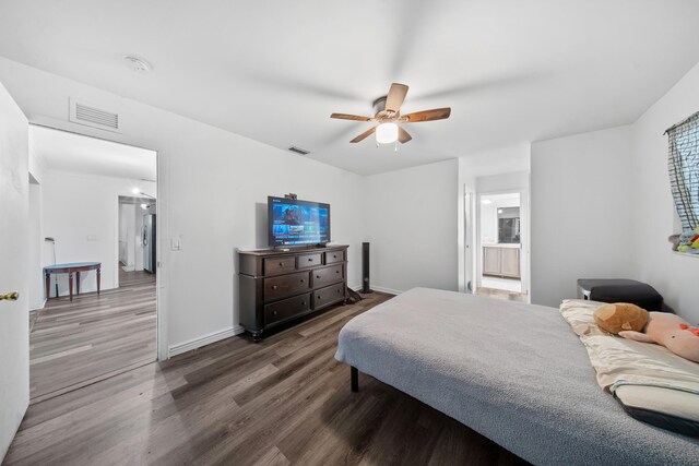 356 SE Prima Vista Blvd, Port Saint Lucie, FL 34983 - bedroom featuring dark wood-type flooring, freestanding refrigerator, ceiling fan, baseboards, and ensuite bath