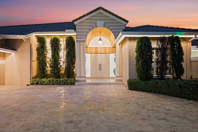 view of front of property featuring a tiled roof and stucco siding
