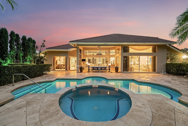 view of swimming pool with a pool with connected hot tub, a patio area, and a ceiling fan