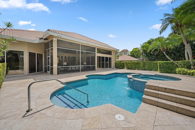 view of swimming pool with a sunroom, a patio, and a pool with connected hot tub