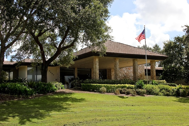view of front of home with stone siding and a front yard