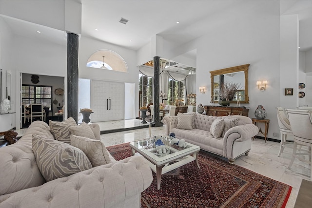 living room with light marble finish flooring, a high ceiling, and recessed lighting