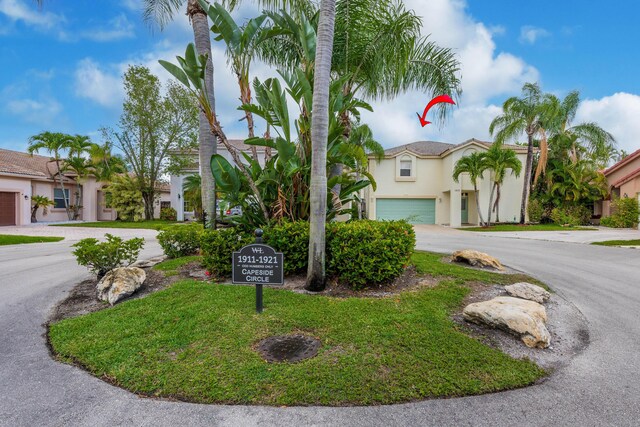 1915 Capeside Cir, Wellington, FL 33414 - mediterranean / spanish-style home with curved driveway, stucco siding, and a garage