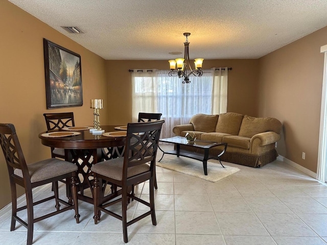 1915 Capeside Cir, Wellington, FL 33414 - dining room featuring a textured ceiling, a chandelier, baseboards, and light tile patterned flooring