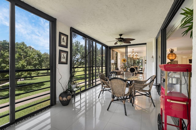 sunroom featuring expansive windows, tile patterned floors, ceiling fan, a textured ceiling, and a chandelier