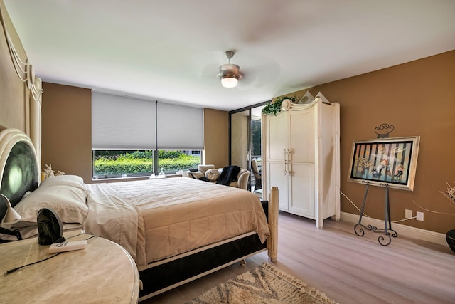 bedroom featuring light wood-style floors, baseboards, and ceiling fan