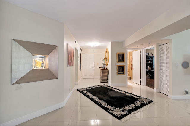 hall with baseboards and tile patterned flooring