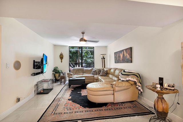 living area with baseboards and ceiling fan