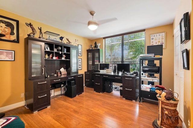 office with light wood finished floors, a ceiling fan, and baseboards