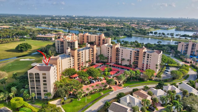 aerial view of apartment complex, a nearby body of water, and a local golf course
