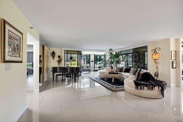 living room with baseboards, light tile patterned floors, and a wall of windows