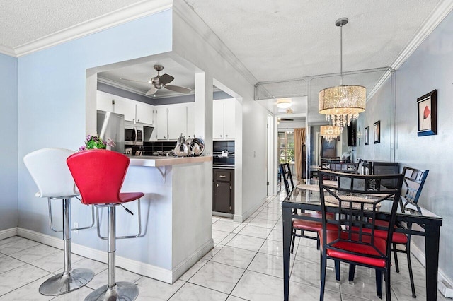 19 Islewood A 19, Deerfield Beach, FL 33442 - kitchen with a textured ceiling, a ceiling fan, a breakfast bar area, white cabinetry, and ornamental molding