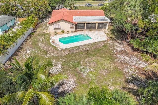 swimming pool featuring a sunroom, a patio area, and a fenced backyard