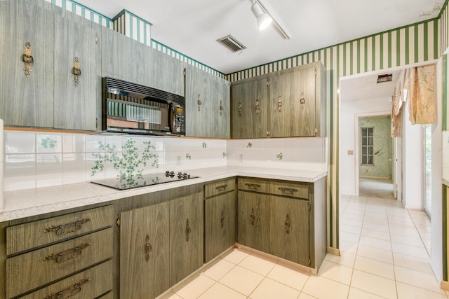 kitchen with black appliances, tasteful backsplash, light tile patterned flooring, and light countertops