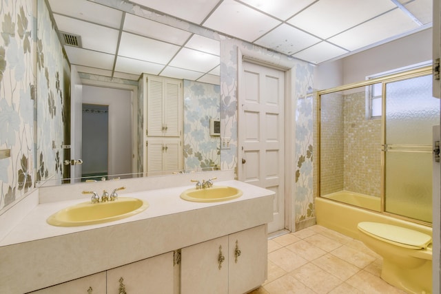 bathroom featuring tile patterned flooring, wallpapered walls, double vanity, combined bath / shower with glass door, and a paneled ceiling