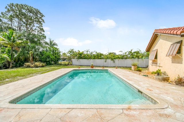 outdoor pool with a fenced backyard and a patio area