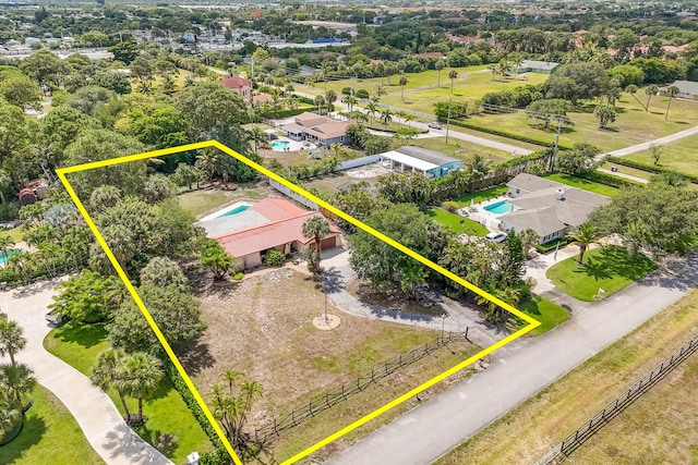 aerial overview of property's location with property boundaries highlighted, a pool, and a tree filled landscape
