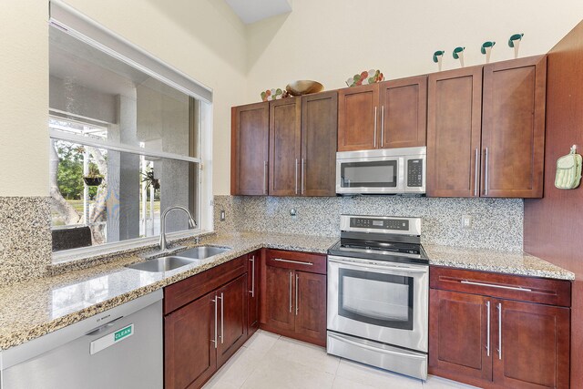 7793 Highlands Cir, Margate, FL 33063 - kitchen with appliances with stainless steel finishes, a sink, decorative backsplash, and light stone counters