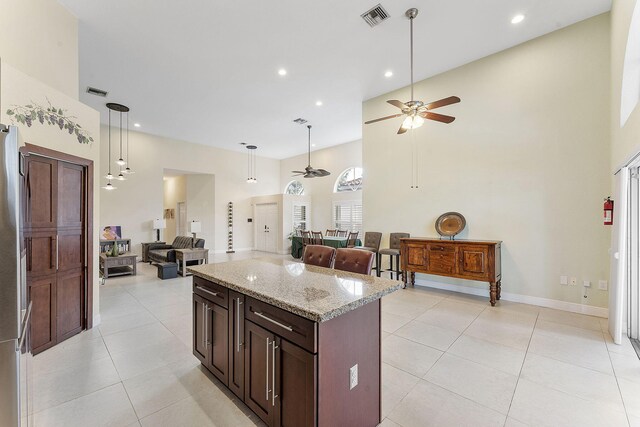 7793 Highlands Cir, Margate, FL 33063 - kitchen with ceiling fan, open floor plan, a high ceiling, a center island, and light stone countertops