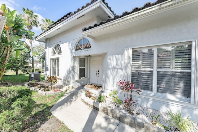 7793 Highlands Cir, Margate, FL 33063 - doorway to property with stucco siding, a tiled roof, and central air condition unit