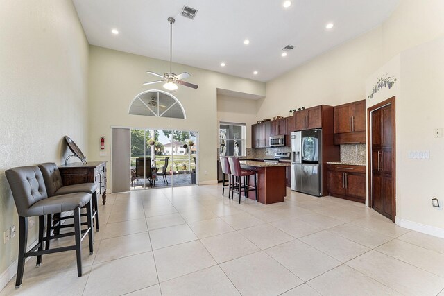 7793 Highlands Cir, Margate, FL 33063 - kitchen featuring appliances with stainless steel finishes, open floor plan, a kitchen breakfast bar, a high ceiling, and a kitchen island