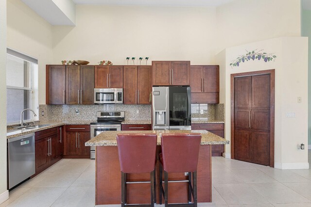 7793 Highlands Cir, Margate, FL 33063 - kitchen featuring appliances with stainless steel finishes, a center island, a high ceiling, a sink, and light tile patterned floors