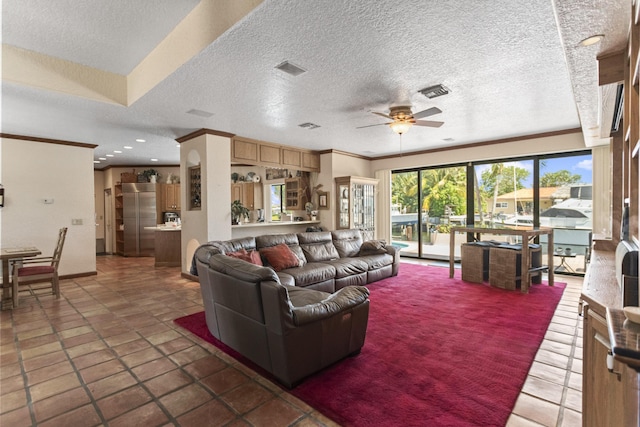 living area with a ceiling fan, a textured ceiling, and crown molding