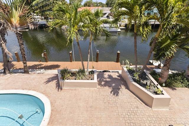 view of swimming pool with a dock and a water view