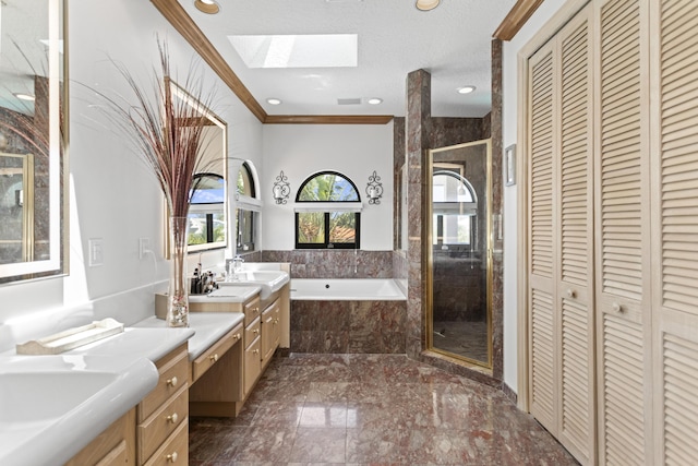 bathroom featuring a skylight, a closet, a bath, marble tiled flooring, and crown molding