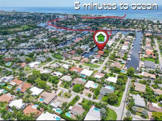 aerial view of property and surrounding area with a nearby body of water and nearby suburban area