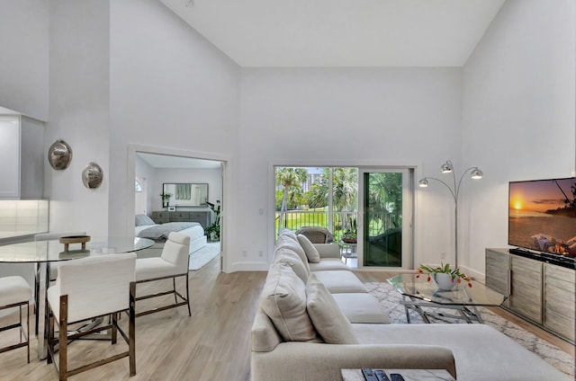 3704 Fairway Dr N, Jupiter, FL 33477 - living room featuring high vaulted ceiling, light wood-style flooring, and baseboards