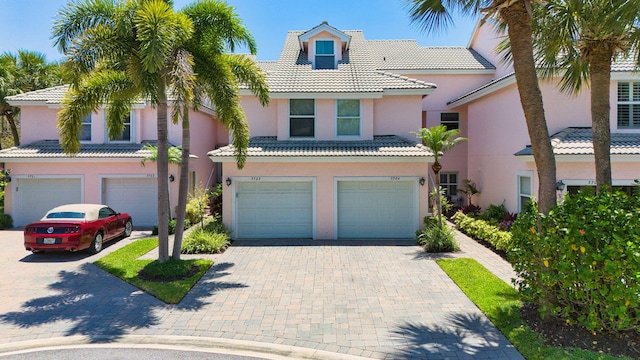 3704 Fairway Dr N, Jupiter, FL 33477 - view of front of house featuring an attached garage, a tiled roof, decorative driveway, and stucco siding