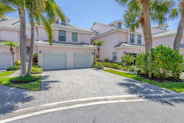 3704 Fairway Dr N, Jupiter, FL 33477 - view of front facade featuring stucco siding, an attached garage, decorative driveway, and a tile roof